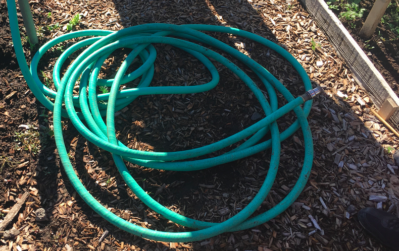 Hose in community garden in Deschutes, OR.