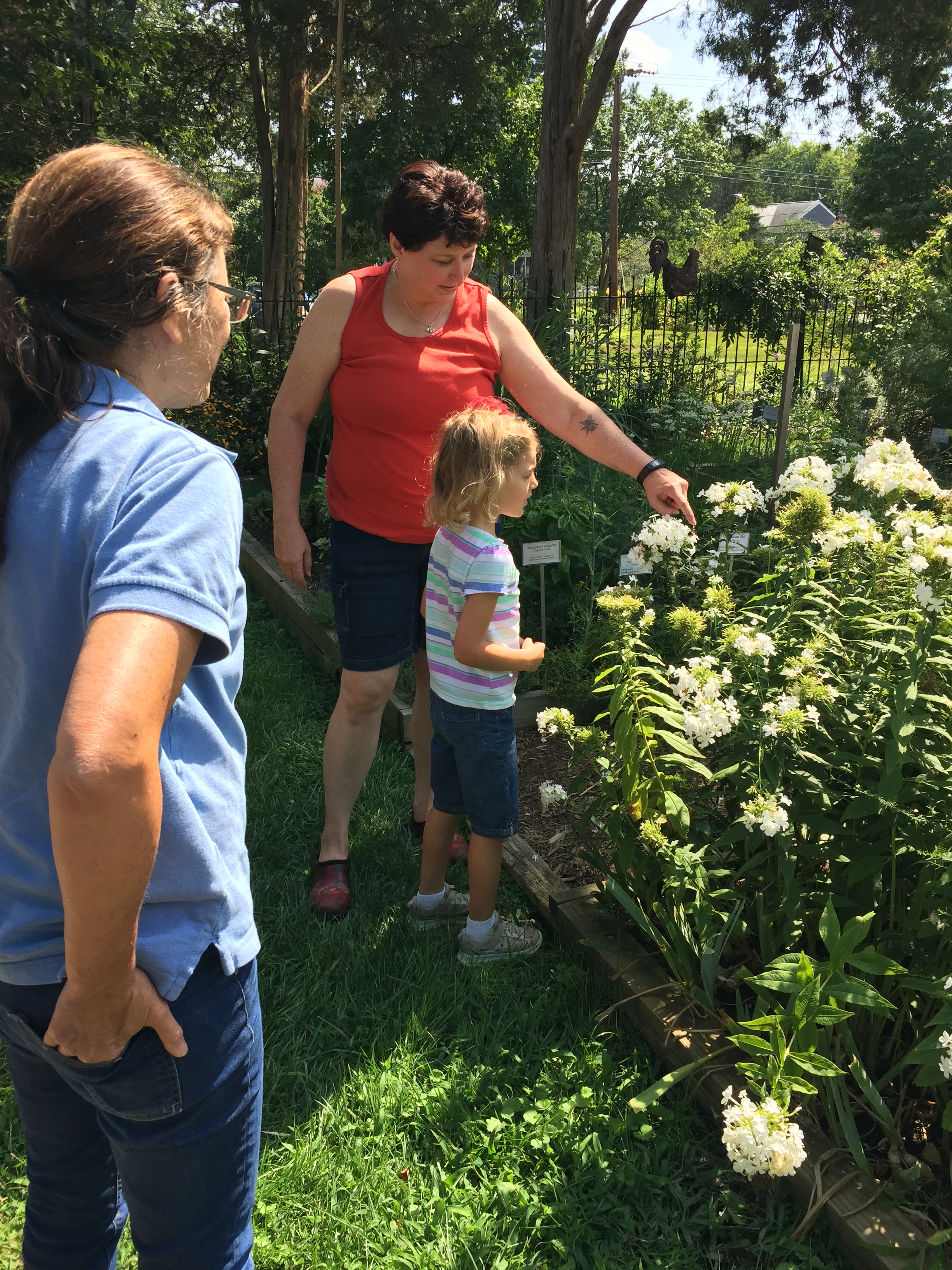 Alyssa teaches a young garden visitor about bumblebees.