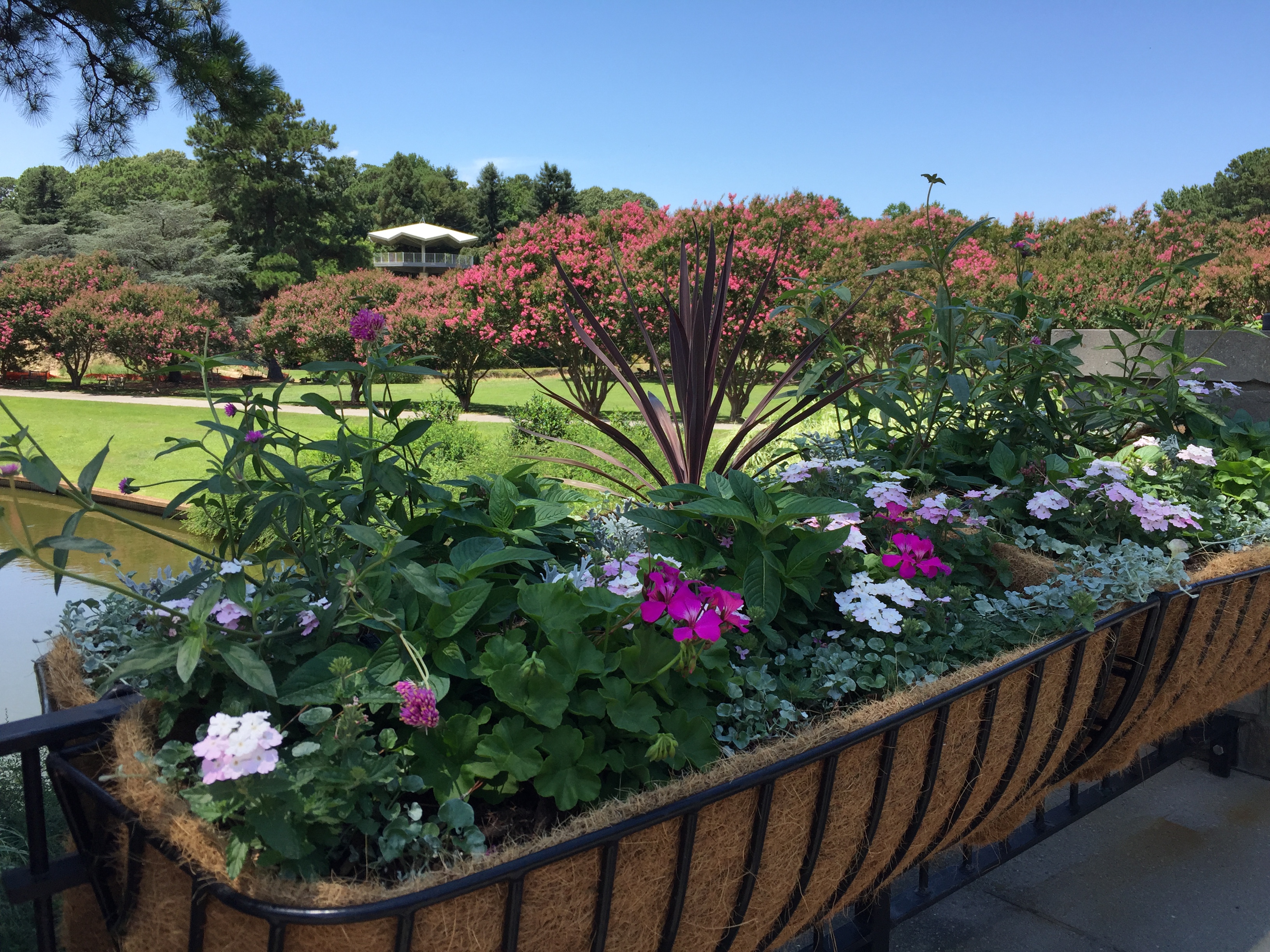 Colorful planters decorate a bridge over the constructed waterway. NATO Tower can be seen in the distance. Photo © 2018 Elaine Mills.