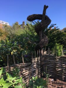 Rod of Asclepius sculpture at Chelsea Physic Garden, London, England Photo © 2019 Nancy Smith Brooks