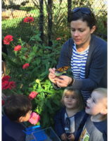 Volunteer with children and monarch butterfly