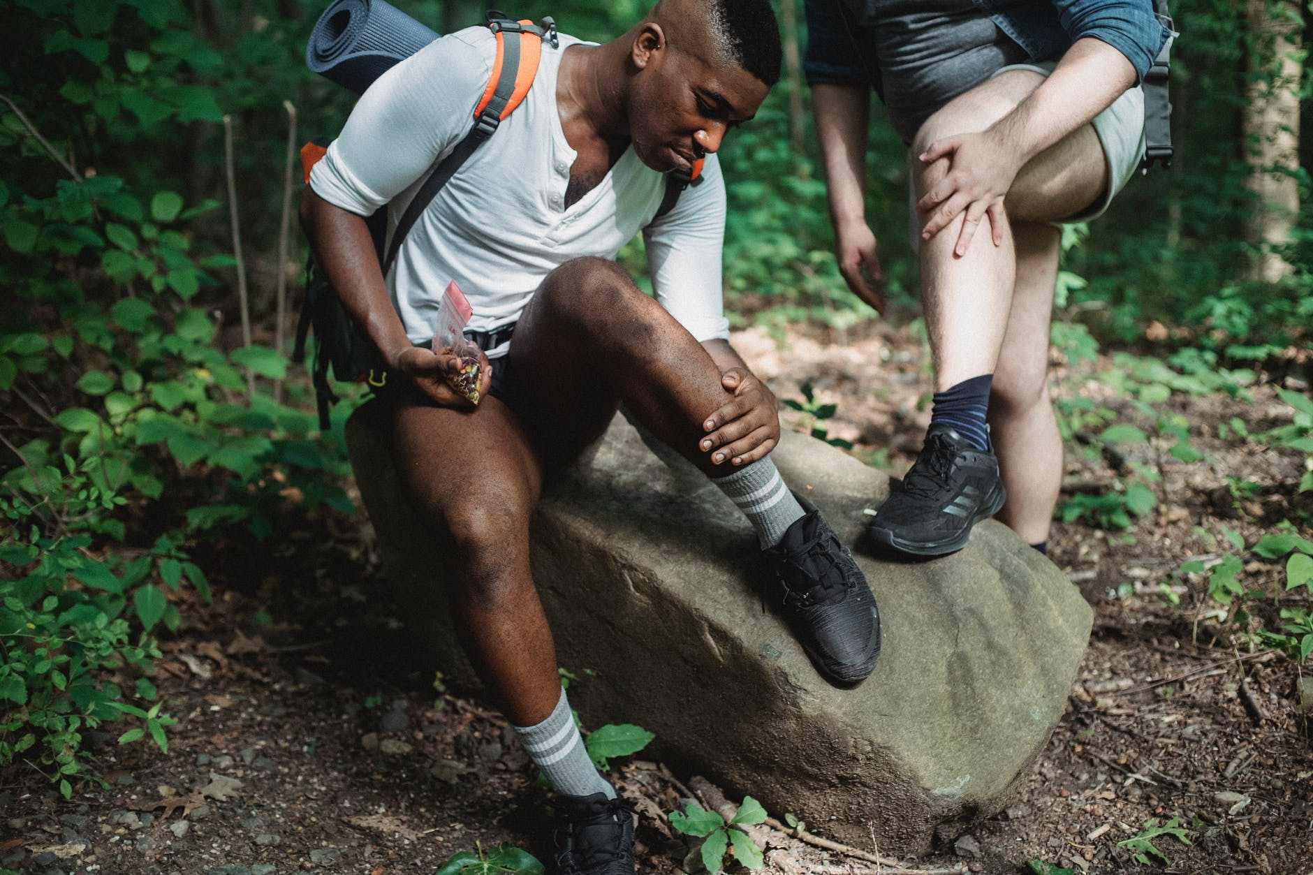 friends checking acari during hike in forest