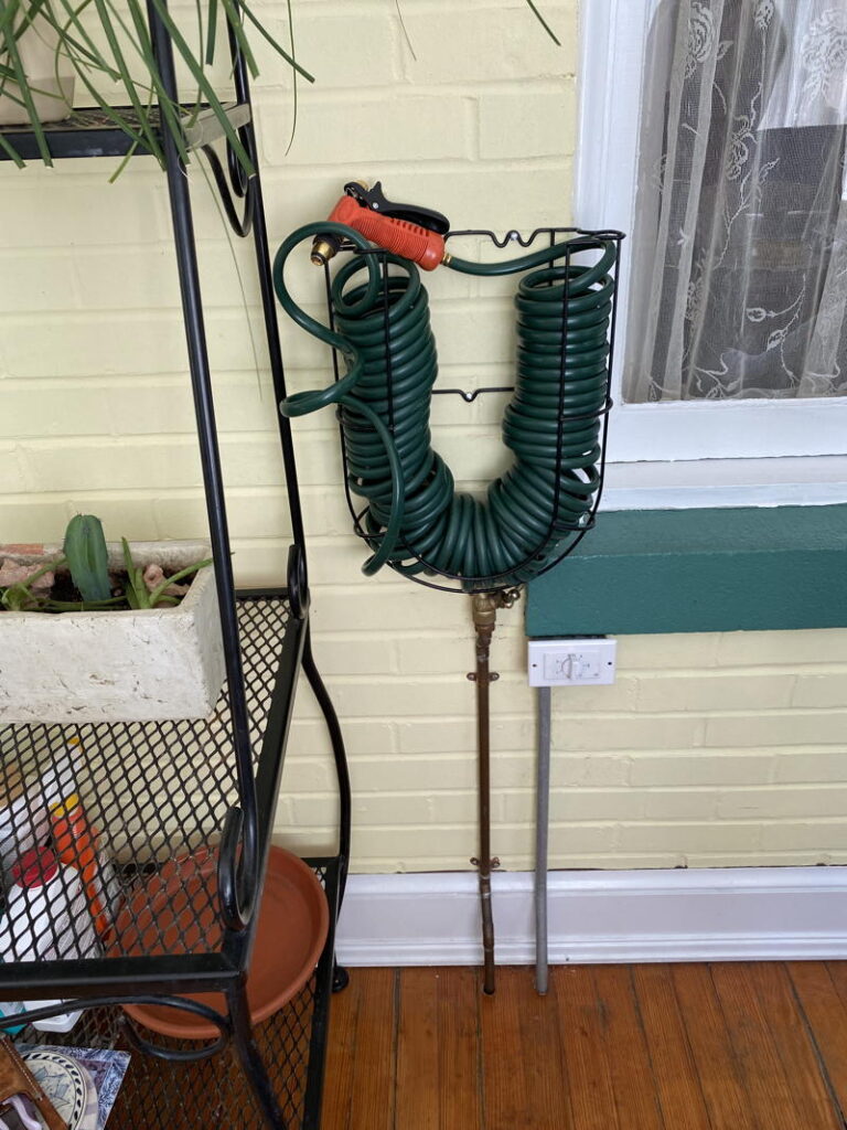 Wall mounted hose on porch