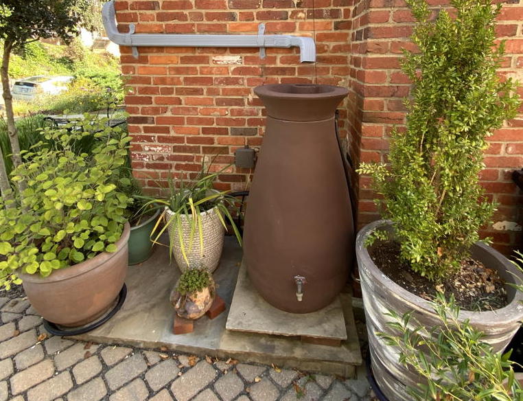 Rain barrel adjacent to permeable driveway.