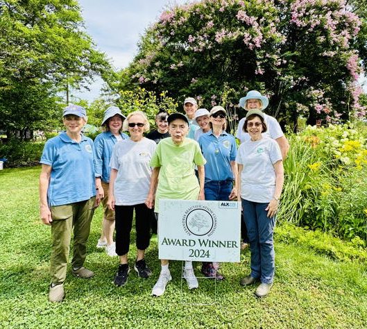 women outdoors with gardening award sign