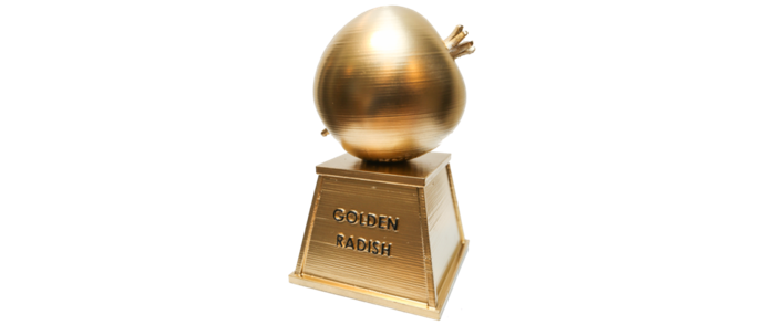 A trophy with a golden surface shaped like a radish sits atop a square pedestal inscribed with 'GOLDEN RADISH'.