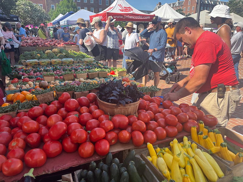 Joe Heishman arranging produce at the Spring Valley Farm and Orchard stands in the Old Town market.