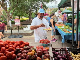 Leonel Lopez from Lopez Farm offering tomato samples at the Old Town market