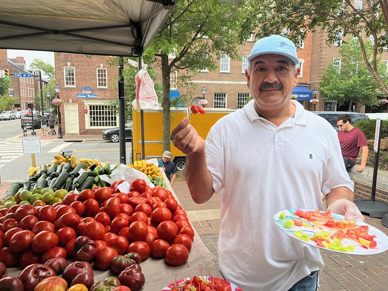 Leonel Lopez from Lopez Farm offering tomato samples at the Old Town market